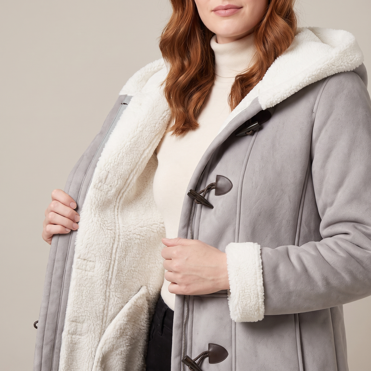 Hazel coat held open to show the soft white lining and toggles